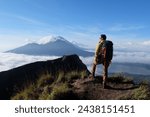 Asian Adventure, Man Model on Mountain Summit, Carrying Hiking Gear under Blue Sky above Ocean of Clouds