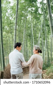 Asian Aged Couple Walking In The Bamboo Forest