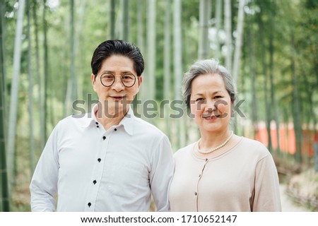 Asian aged couple walking in the bamboo forest