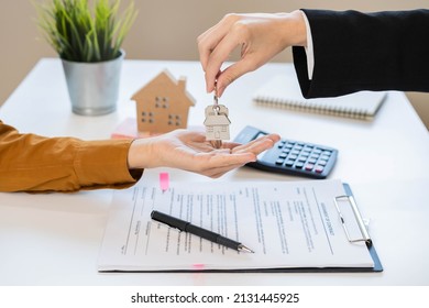 Asian Agent Giving A Key To New Owner Or Tenant, Client After Signed Signature Contract Rental Purchase, Buyer Apartment, Home With Landlord, Realtor. Banker Agreement Mortgage Loan. Property Lease.