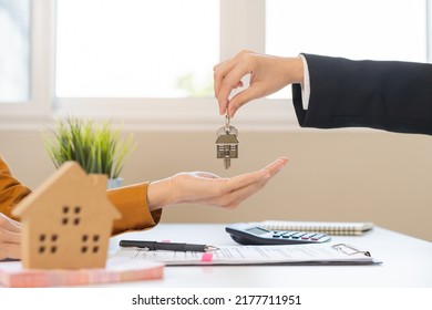 Asian Agent Giving A Key To New Owner Or Tenant, Client After Signed Signature Contract Rental Purchase, Buyer Apartment, Home With Landlord, Realtor. Banker Agreement Mortgage Loan. Property Lease.