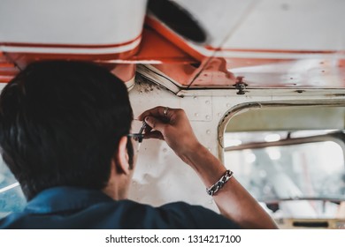 Asian Aircraft Maintenance Engineer Installing Parts Into The Small Aircraft In The Hanger