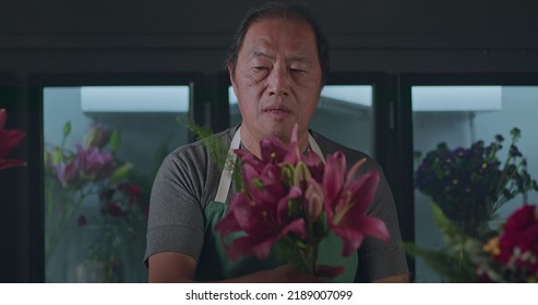 An Asian American Florist Preparing Bouquet Of Flowers For Online Delivery. Portrait Of An Artisan Male Florist Creating Artistic Arrangement For Client At Flower Shop