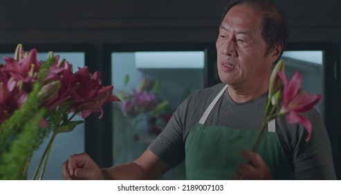 An Asian American Florist Preparing Bouquet Of Flowers For Online Delivery. Portrait Of An Artisan Male Florist Creating Artistic Arrangement For Client At Flower Shop