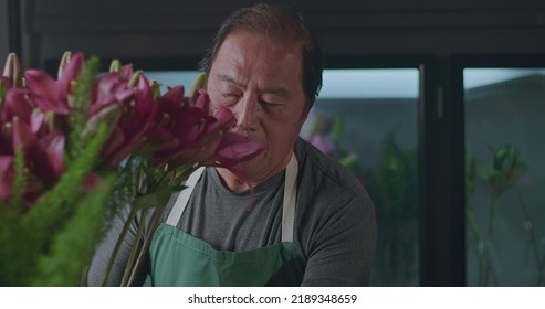 An Asian American Florist Preparing Bouquet Of Flowers For Online Delivery. Portrait Of An Artisan Male Florist Creating Artistic Arrangement For Client At Flower Shop