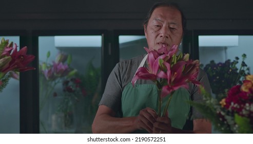 An Asian American Florist Preparing Bouquet Of Flowers For Online Delivery. Portrait Of An Artisan Male Florist Creating Artistic Arrangement For Client At Flower Shop