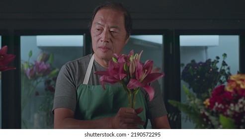 An Asian American Florist Preparing Bouquet Of Flowers For Online Delivery. Portrait Of An Artisan Male Florist Creating Artistic Arrangement For Client At Flower Shop