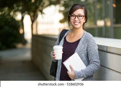 Asian American University Student Smiling With Coffee And Book Bag On Campus With Print Space