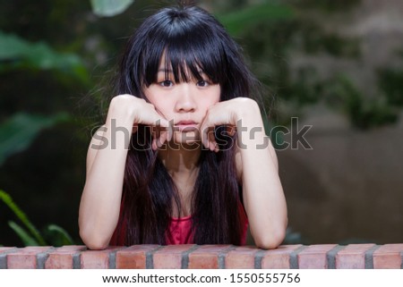 Asian American woman looks sad and forlorn