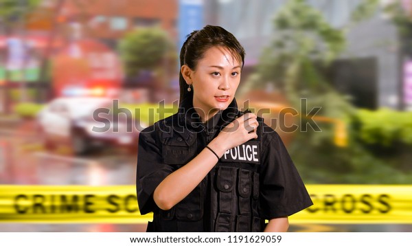 Asian American Woman Police Officer at Crime
scene Calling for Backup on CB
Radio