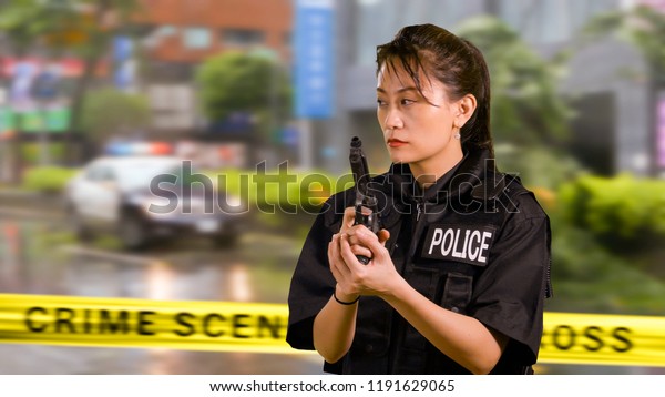Asian American Woman Police Officer at Crime\
scene Holding Pistol\
Firearm