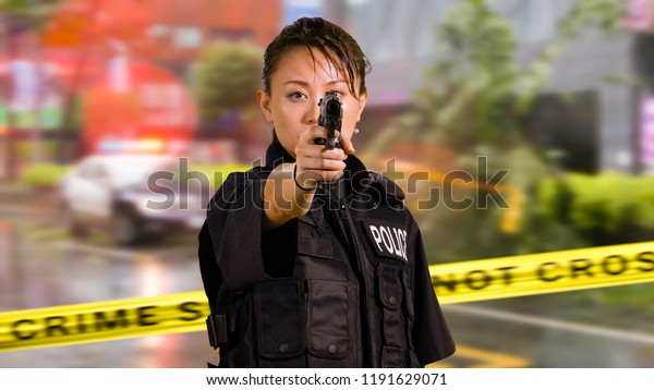 Asian American Woman Police Officer at Crime
scene Holding Pistol
Firearm