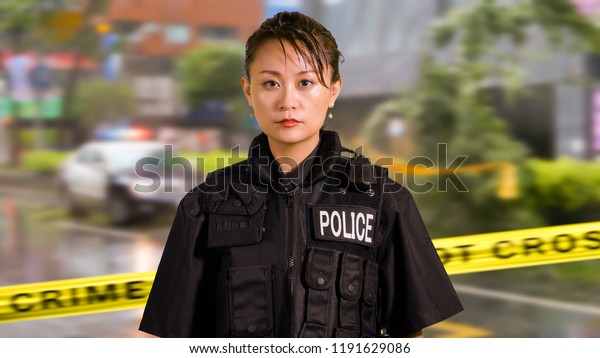 Asian American Woman Police Officer at Crime\
scene Holding Pistol\
Firearm
