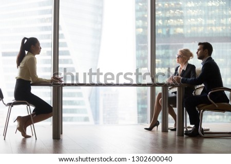 Asian applicant introducing talking to hr managers at job interview in modern office, recruiters interviewing listening to vacancy candidate recruiting sitting at table, hiring and employment concept