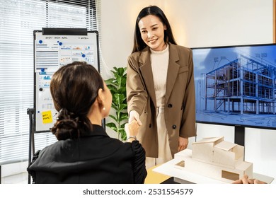 Asian Architects and department manager teamwork shaking hands after success presentation 3D architectural displayed model, negotiation and deal in meeting or casual, Greeting - Powered by Shutterstock