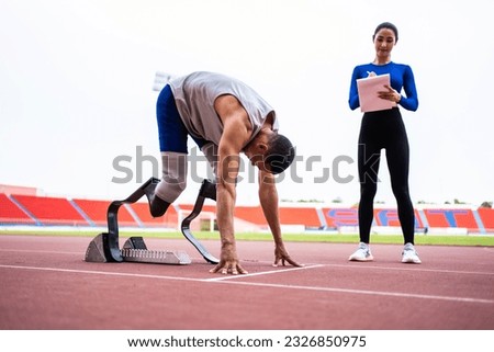 Asian athlete with prosthetic blades and trainer workout in stadium. Attractive amputee male runner and young sportswoman feel happy and enjoy practicing workout for Paralympics running competition.