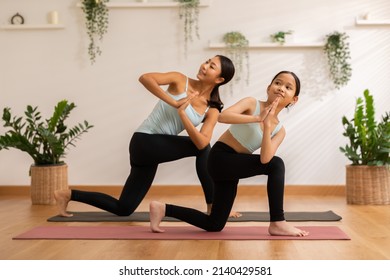 Asian Athletes, Woman And Kid Practicing Yoga Together Posing Yoga Stretching Smile To Each Other In Home Studio.Two Females Mom And Daughter Healthy Workout At Home, Exercise, Fit, Doing Yoga Fitness