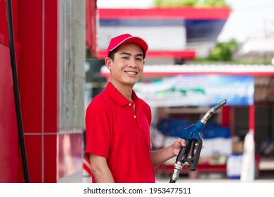 Asian Attendant Service Male Worker Holding Pipe Nozzle At Gas Station. Young Assistant Man Refuelling Car At Petrol Station With Happy, Smile And Wear Red Uniform And Red Hat