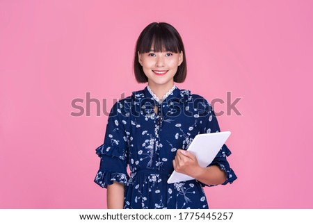 Asian attractive cute short hair woman happy smiling using smart tablet device technology confident independent mother businesswoman planning research wearing dress pink isolated background portrait