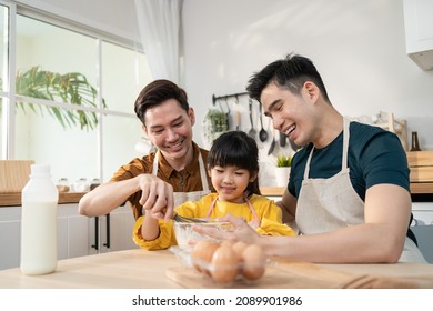 Asian Attractive LGBTQ Gay Family Teach Girl Kid Making Yeast Dough. Handsome Male Couple Take Care And Spend Time With Little Adorable Child Bake Bakery In Kitchen, Enjoy Parenting Activity At Home.