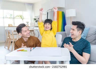 Asian Attractive LGBTQ Gay Family Teach Young Girl Kid Draw Picture. Handsome Male Couple Look At Little Adorable Child Daughter Play And Coloring Book In Living Room, Enjoy Parenting Activity At Home