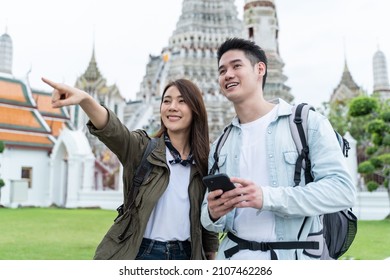 Asian Attractive Romantic Couple Travel In The City For Honeymoon Trip. New Marriage Man And Woman Backpacker Tourist Use Mobile Phone Find Destination, Enjoy Spend Time On Holiday Vacation Together.