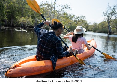 Asian Attractive Romantic Young Couple Rowing Kayak In A Forest Lake. Backpacker Man And Woman Travel And Kayaking On Canoe In Beautiful Mangrove Forest Enjoy Spend Time On Holiday Vacation Together.