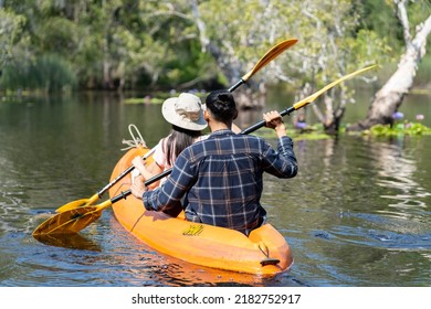 Asian Attractive Romantic Young Couple Rowing Kayak In A Forest Lake. Backpacker Man And Woman Travel And Kayaking On Canoe In Beautiful Mangrove Forest Enjoy Spend Time On Holiday Vacation Together.