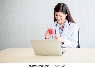 Asian Attractive Woman Doctor Looking At And Using A Computer Notebook To Provide Advice To Heart Disease Patients By Communication Online, To Health Care And Doctor Online Concept.