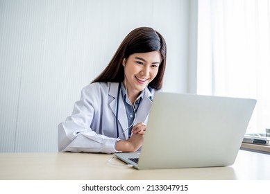 Asian Attractive Woman Doctor Looking At And Using A Computer Notebook To Provide Advice To Patients By Communication Online, To Health Care And Doctor Online Concept.