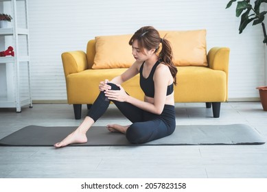 Asian Attractive Young Woman, Is Currently Having A Knee Injury During His Exercise In Home, Due To Osteoarthritis, To Sports And Health Care Concept.