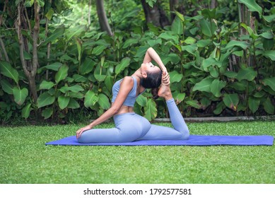 Asian attractive young woman have a beautiful body, Playing yoga in an elegant posture, in the green park, concept to people recreation and health care concept. - Powered by Shutterstock