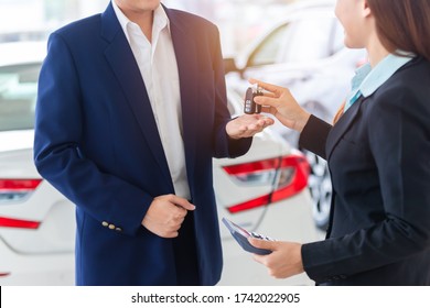 Asian Auto Business, Car Sale, Deal, Gesture And People Concept - Close Up Of Dealer Giving Key To New Owner In Auto Showroom