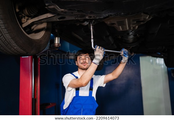 Asian auto mechanic in car garage. Vehicle service
personnel are inspecting cars in mechanic factory with confidence
in car engine repairs. Asian mechanic with equipment to fix cars in
the service. 