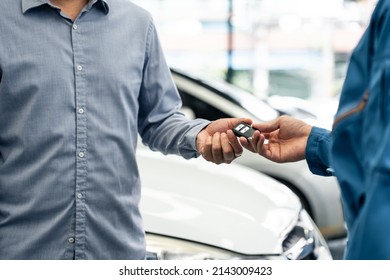 Asian Automotive Mechanic Repairman Handing Car Remote Key To Client. Vehicle Service Manager Give The Key Back To Car Owner After Successful Of Checking And Maintenance Car Engine In Mechanics Garage