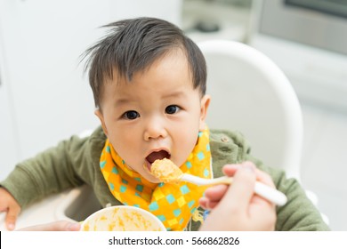 Asian Baby Boy Eating Blend Food On A High Chair