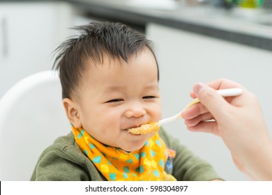 Asian Baby Boy Eating Blend Food On A High Chair