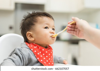 Asian Baby Boy Eating Blend Food On A High Chair