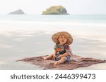 Asian baby boy is sitting on the beach and sea on holiday