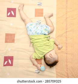 Asian Baby Boy Sleeping On The Bed , His Right Hand Holding  Milk Bottle, Top View Photo