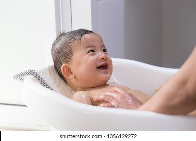 Asian Baby Boy Taking A Bath By Mom. Hygiene And Care For Young Children Concept