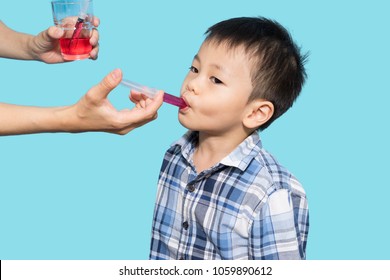 Asian Baby Boy Taking Medicine By Using Syringe, Baby Illness And Care, Blue Background