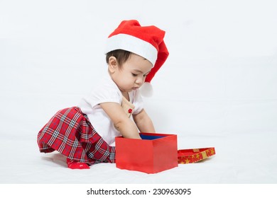 Asian Baby With Christmas Cap Pick Up Something In Gift Box