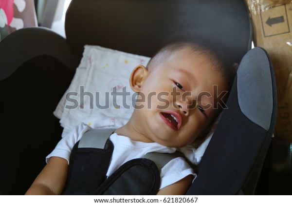 Asian baby crying on car\
seat
