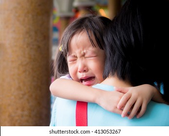 Asian baby girl hugging her mother crying