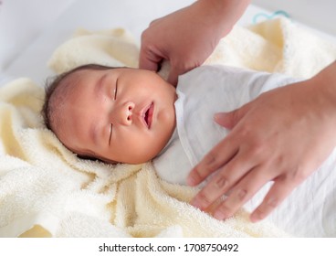 The Asian Baby Girl Just Took A Shower. She Is Lying Down And Let Her Mother Swaddle With Soft And Clean White Fabric. She Has Some Rash On Her Eyebrows.