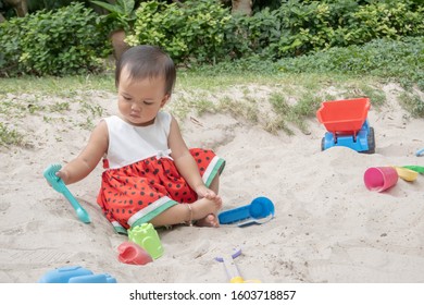 Asian Baby Girl Playing Sand Outdoor. Kid Building Sand Castle. 