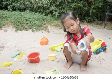 Asian Baby Girl Playing Sand Outdoor. Kid Building Sand Castle. 