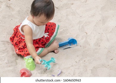 Asian Baby Girl Playing Sand Outdoor. Kid Building Sand Castle. 