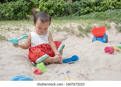 Asian Baby Girl Playing Sand Outdoor. Kid Building Sand Castle. 